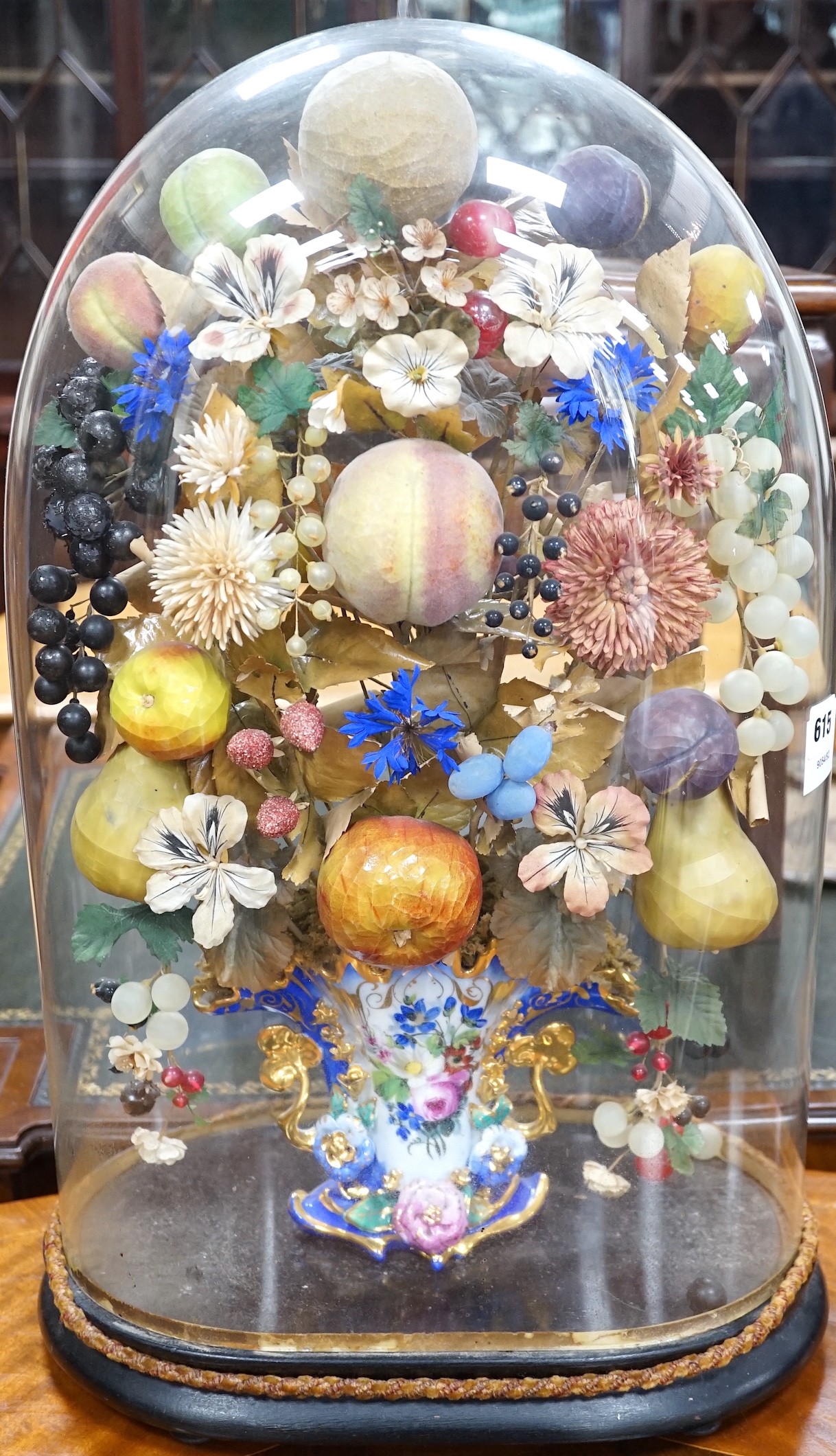 A Victorian painted mache fruit arrangement under a glass dome, 58cms high